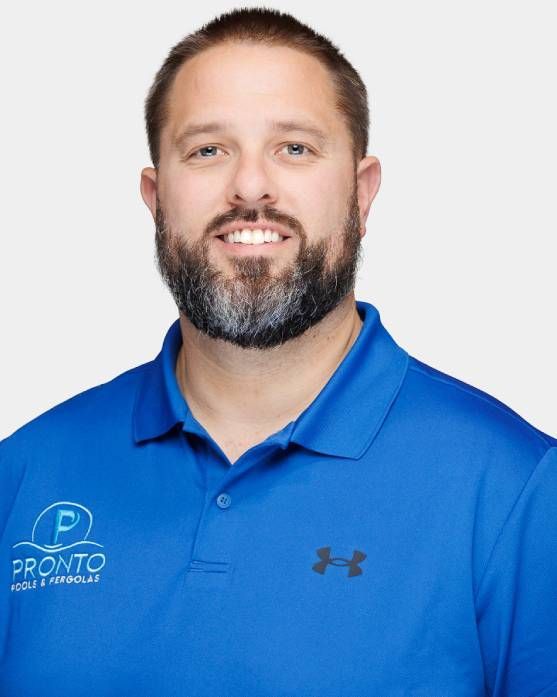 Man in blue polo shirt smiling against a white background