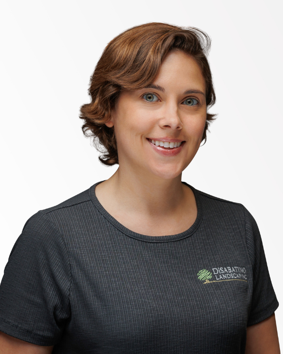Smiling woman in a dark gray shirt against a light background