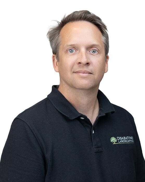 Portrait of a man in a black polo shirt against a white background