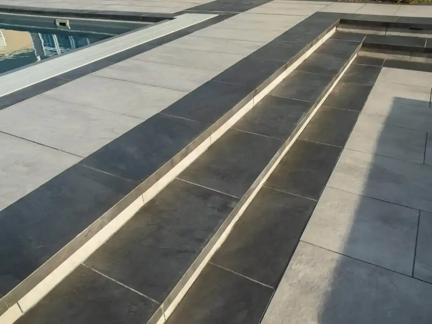 Modern rooftop with long rectangular skylight or drainage channels and light gray paving tiles