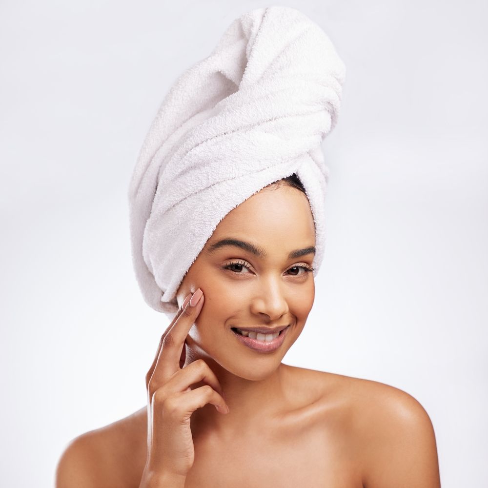 Woman with bath towel around hair and hand on cheek