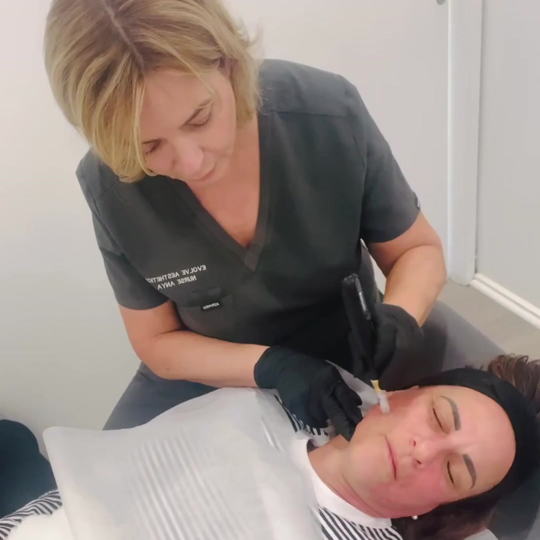 Woman receiving cosmetic treatment on face