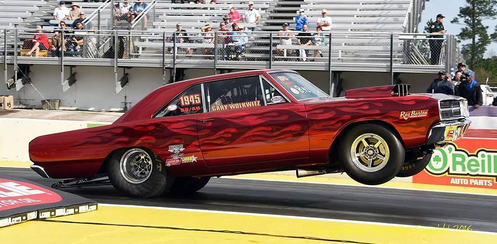 A red car is driving down a race track.