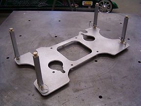 A piece of metal is sitting on top of a metal table.