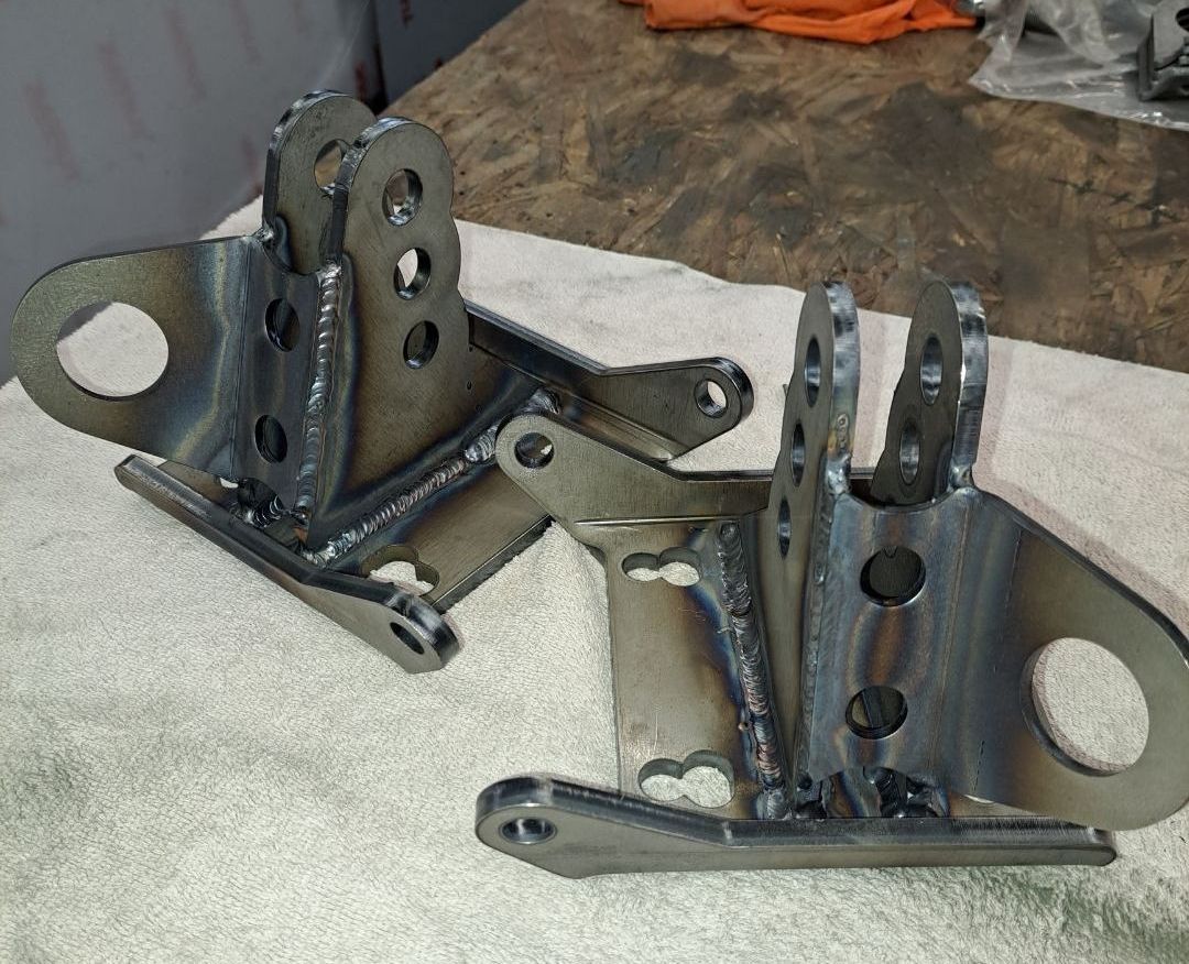 A pair of metal brackets are sitting on a towel on a table.