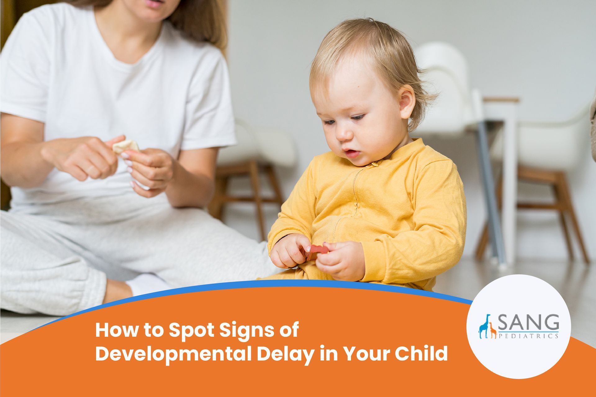 A woman is sitting next to a baby who is playing with a toy.