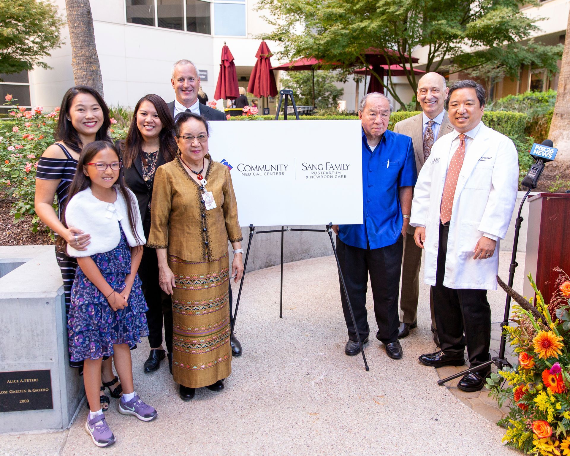 A group of people are posing for a picture in front of a sign.