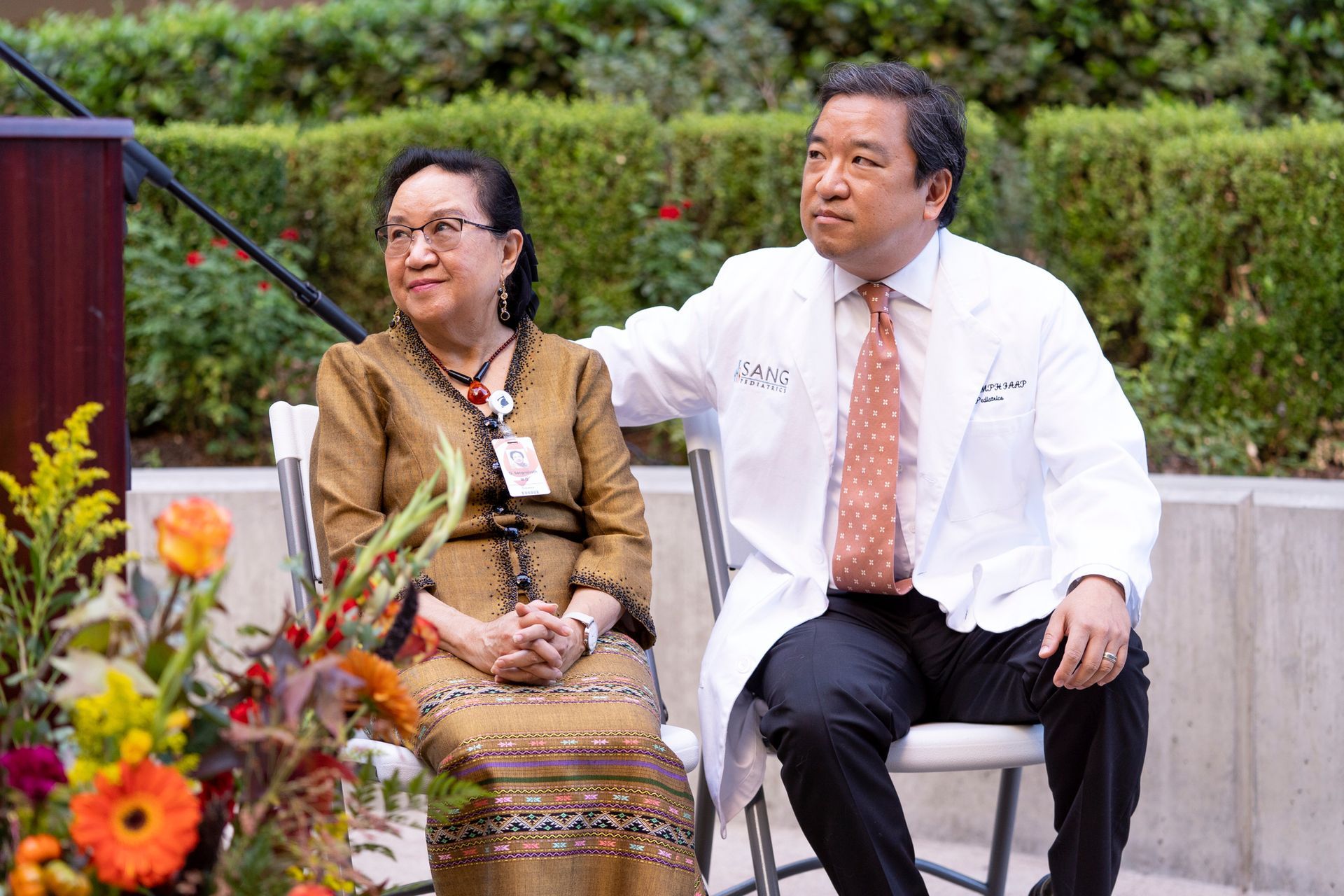 A man and a woman are sitting next to each other in front of a podium.