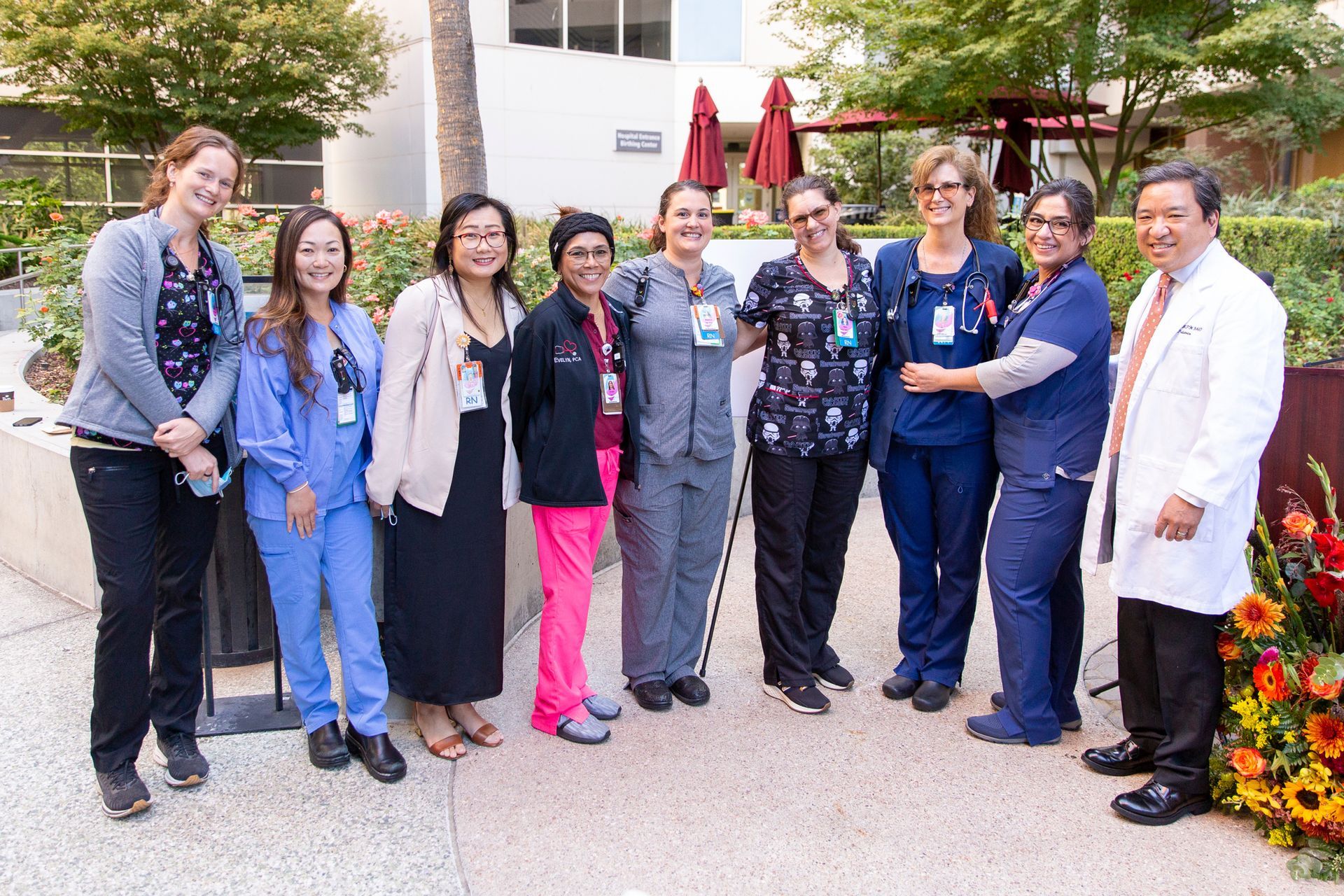 A group of nurses and doctors are posing for a picture.