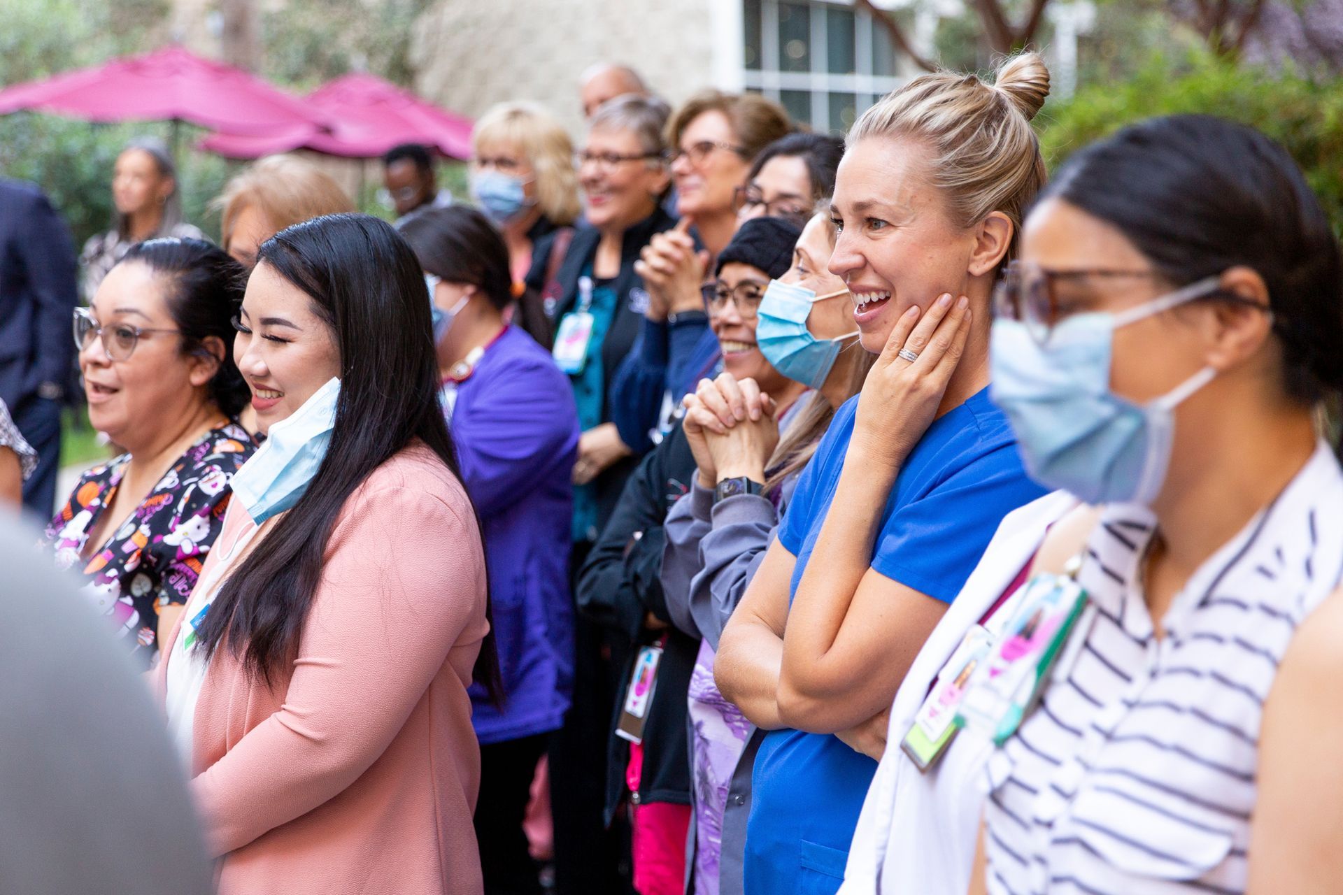 A group of women wearing face masks are standing in a line.