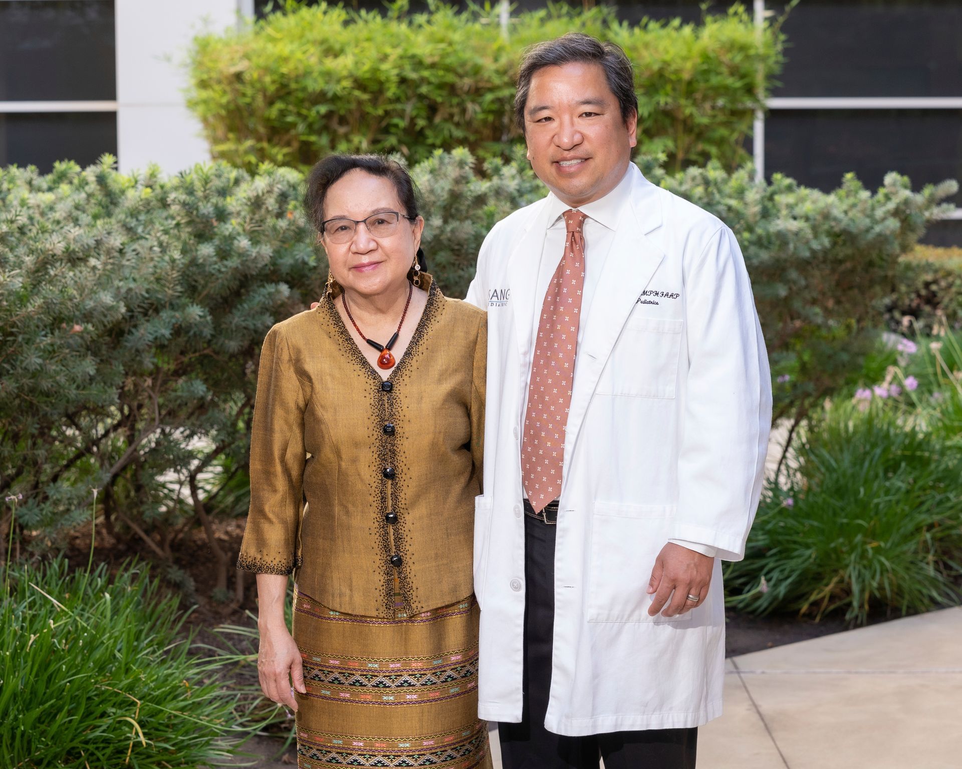 A man and a woman are standing next to each other in front of a building.