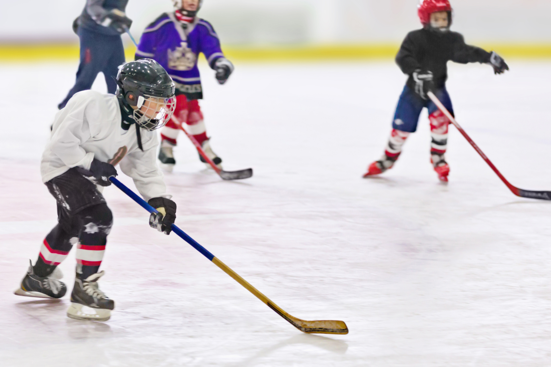 A group of young healthy athletes playing together in a hockey rink.