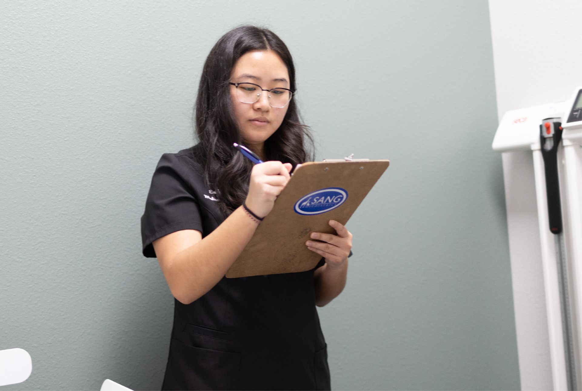 A person is writing on a piece of paper with a pen.