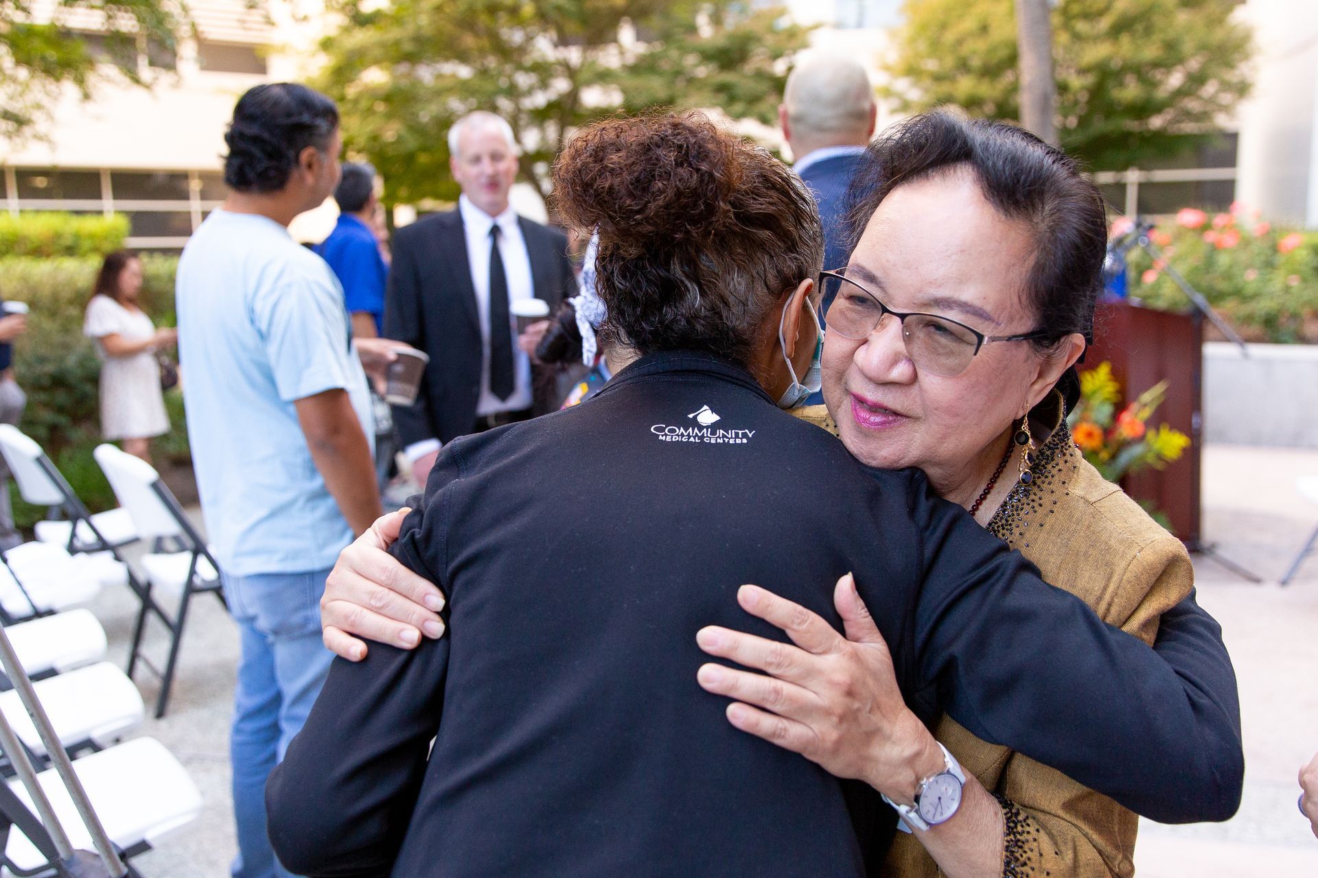 A woman is hugging another woman in front of a crowd of people.