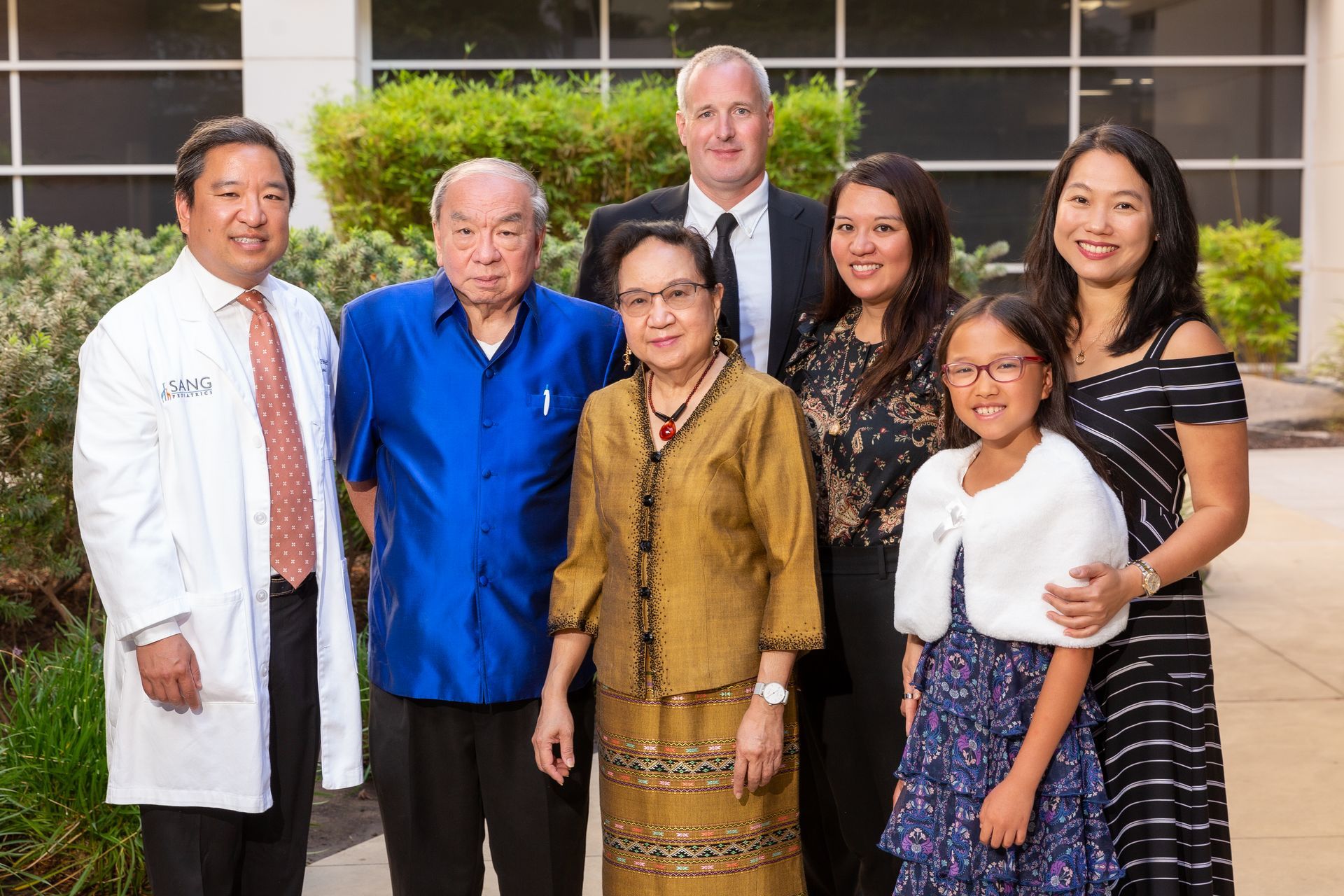 A group of people standing next to each other in front of a building.