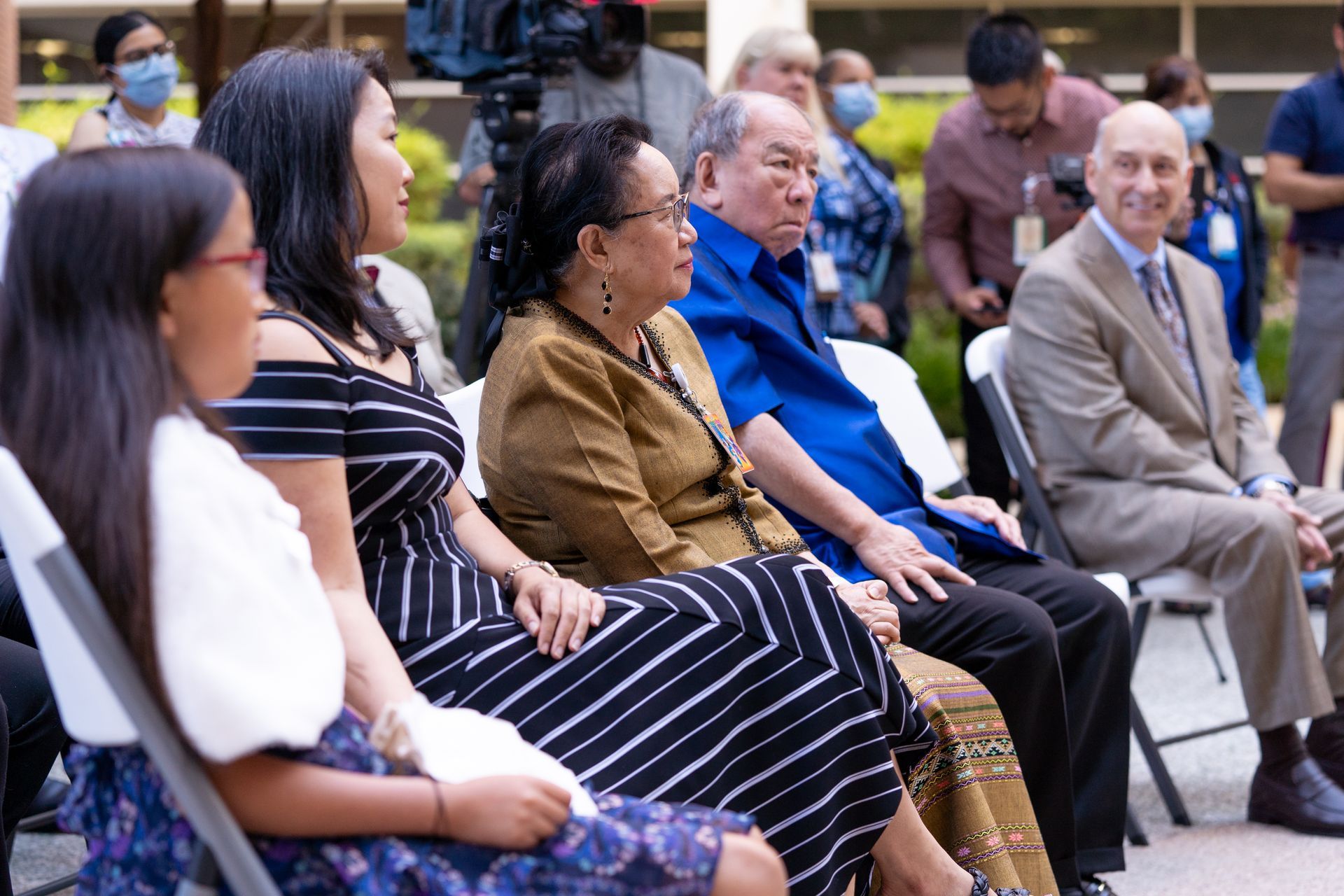 A group of people are sitting in chairs watching a presentation.