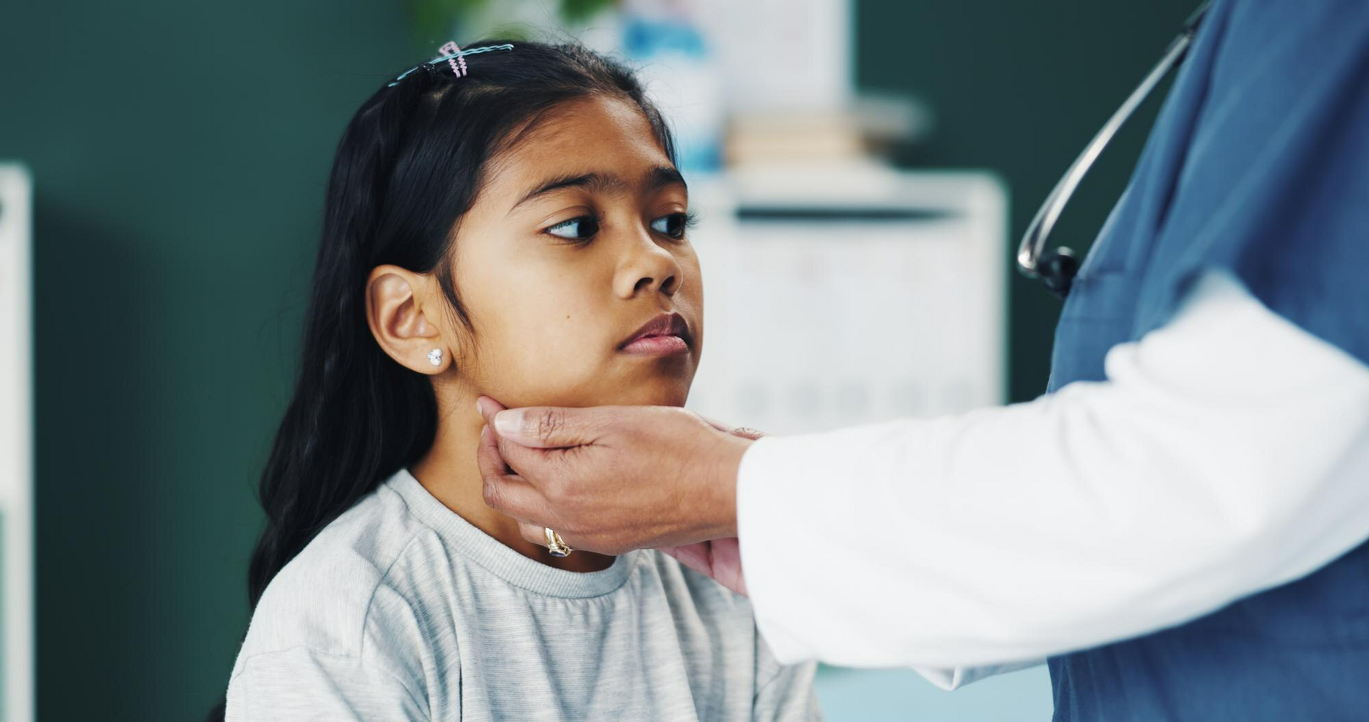 A pediatrician checks a child’s throat to see if he has strep throat symptoms. 