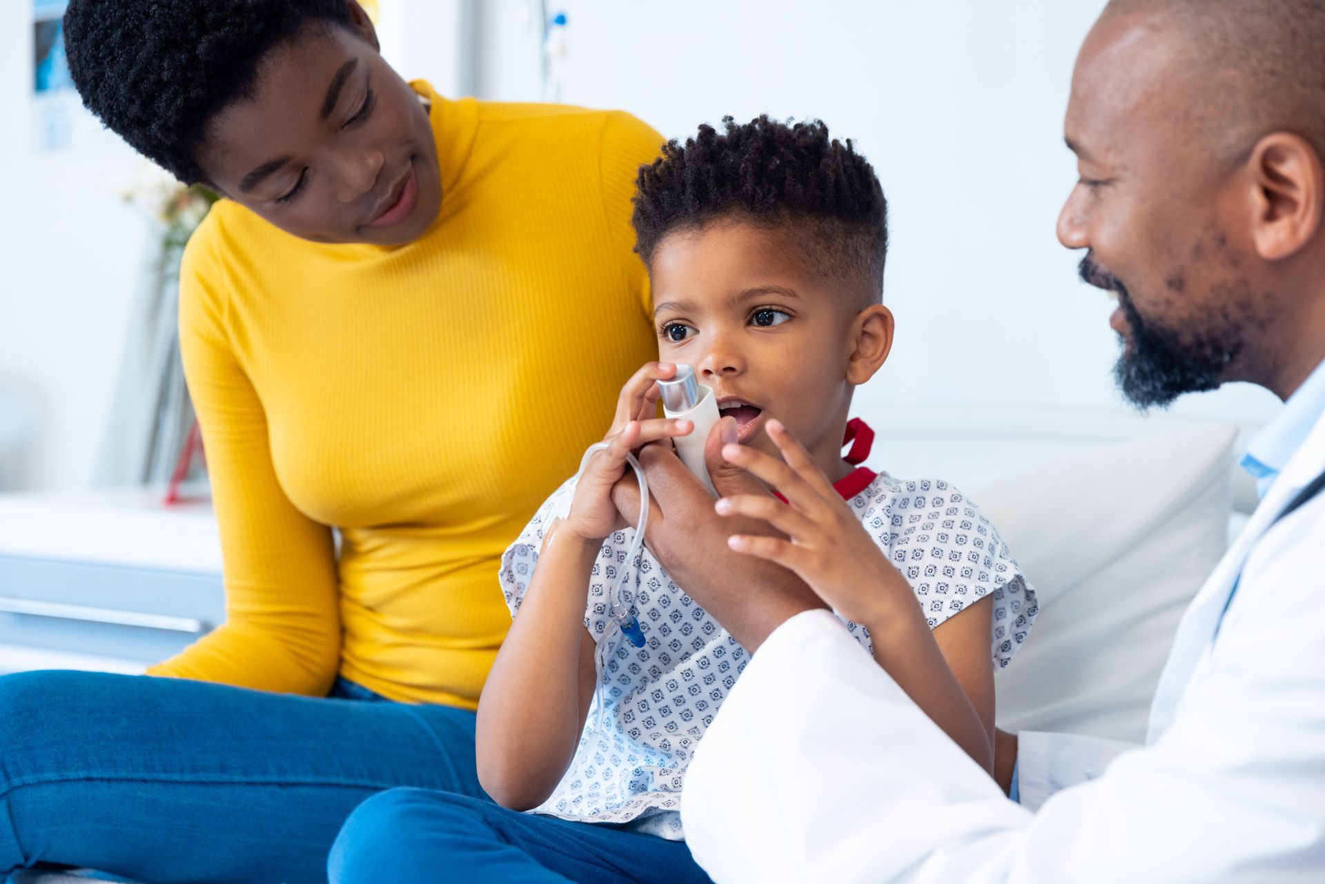 A doctor is giving a child an inhaler in a hospital room.