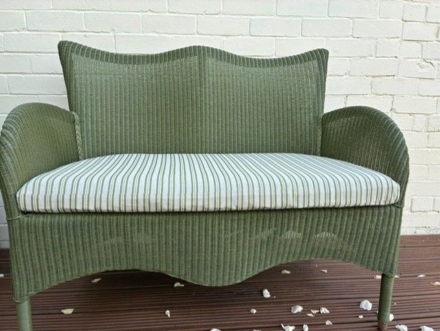 Green wicker loveseat with striped cushion