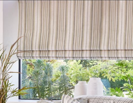 A living room with a striped roman blind.