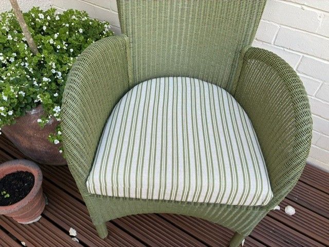 Green wicker chair with striped cushion