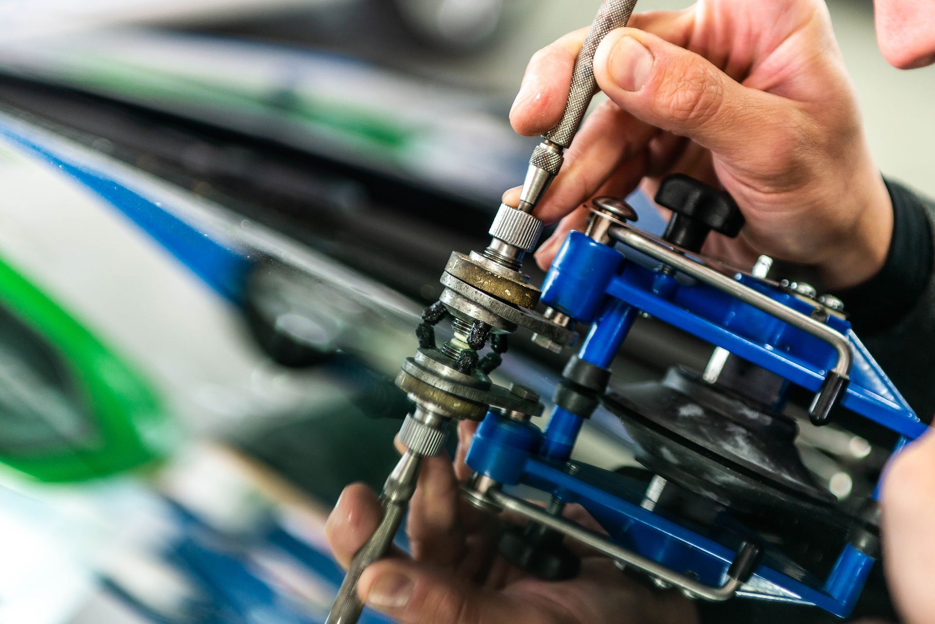 Person using tools to repair a car windshield