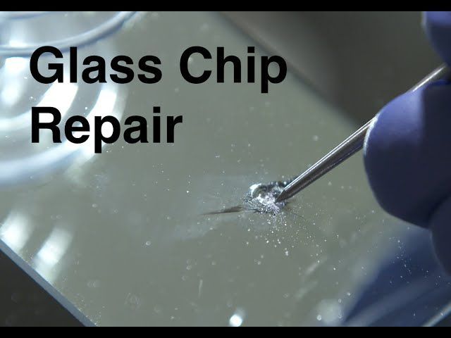 Person in blue gloves using a tool to repair a chip in glass. The words 