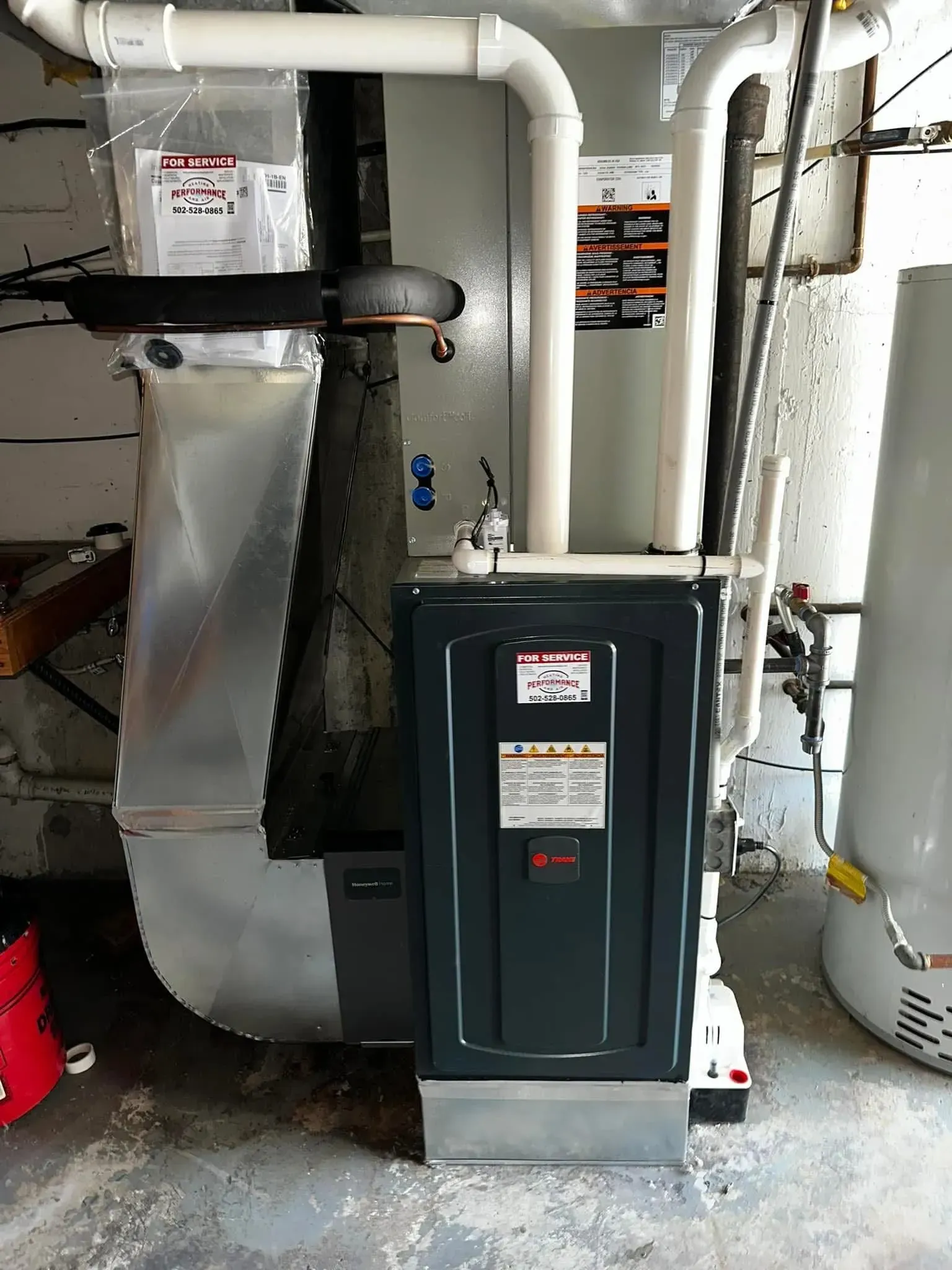 Basement furnace and HVAC ductwork with pipes and utility equipment.