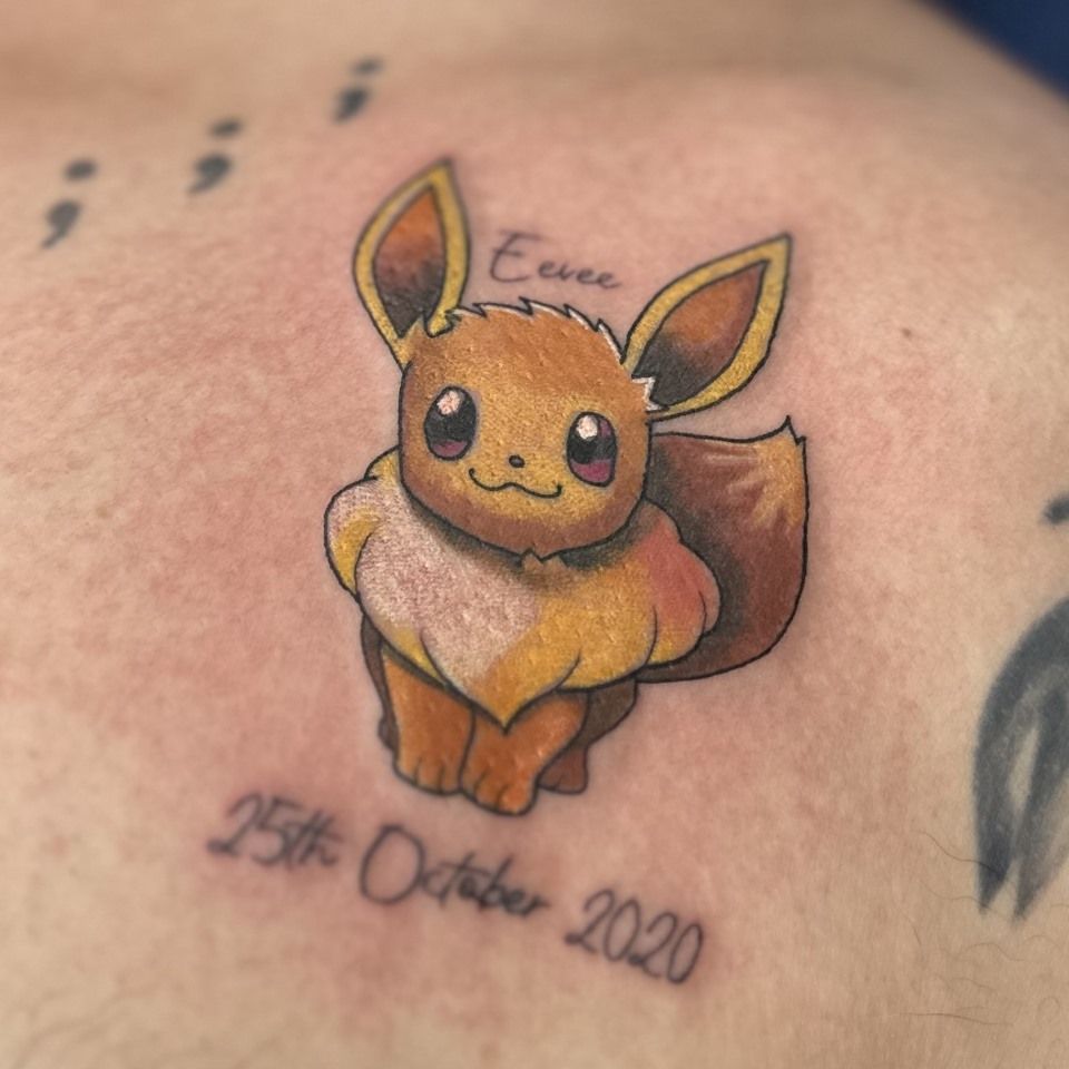 Tattoo of Eevee Pokémon with the date 
