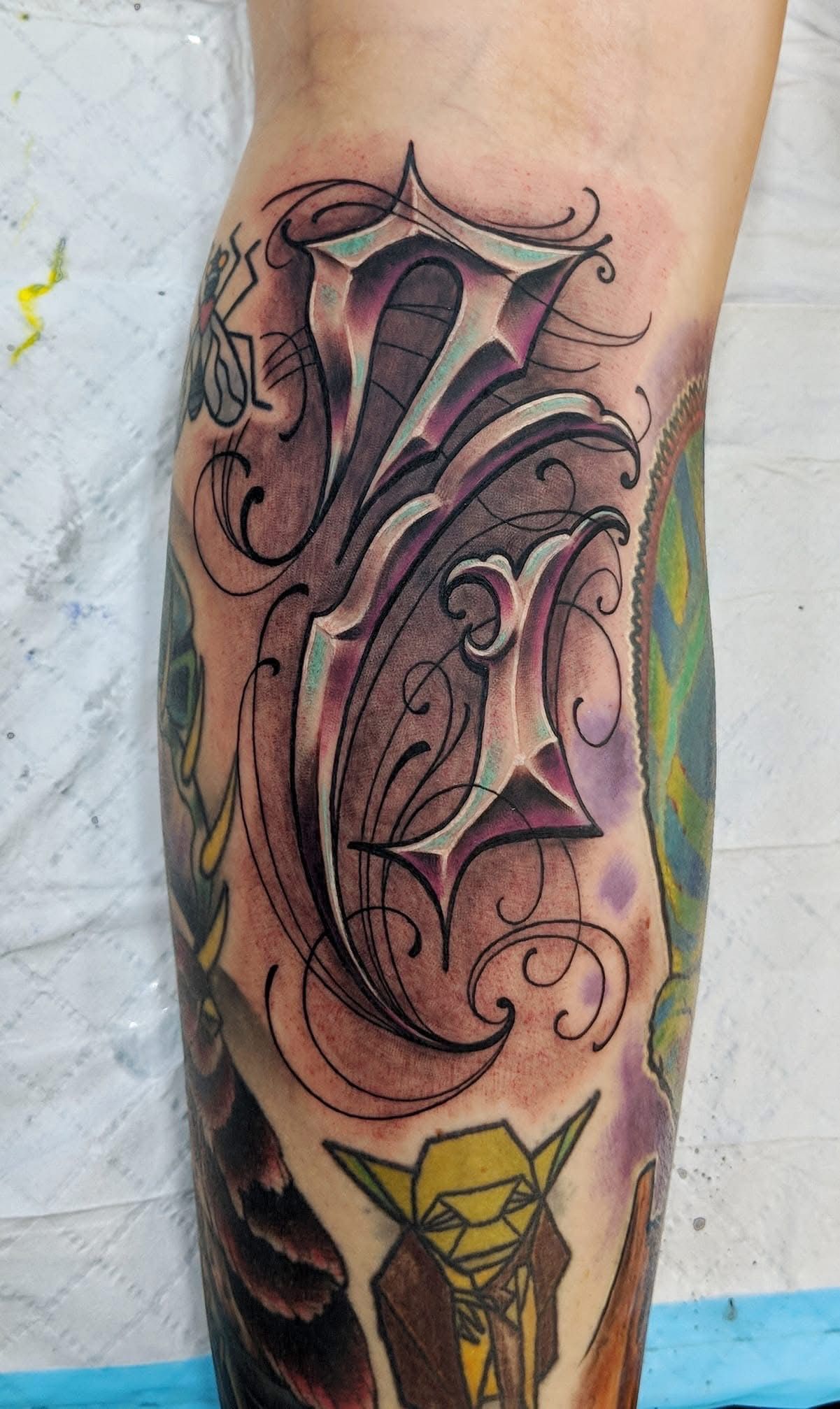 Tattoo of a stylized letter 