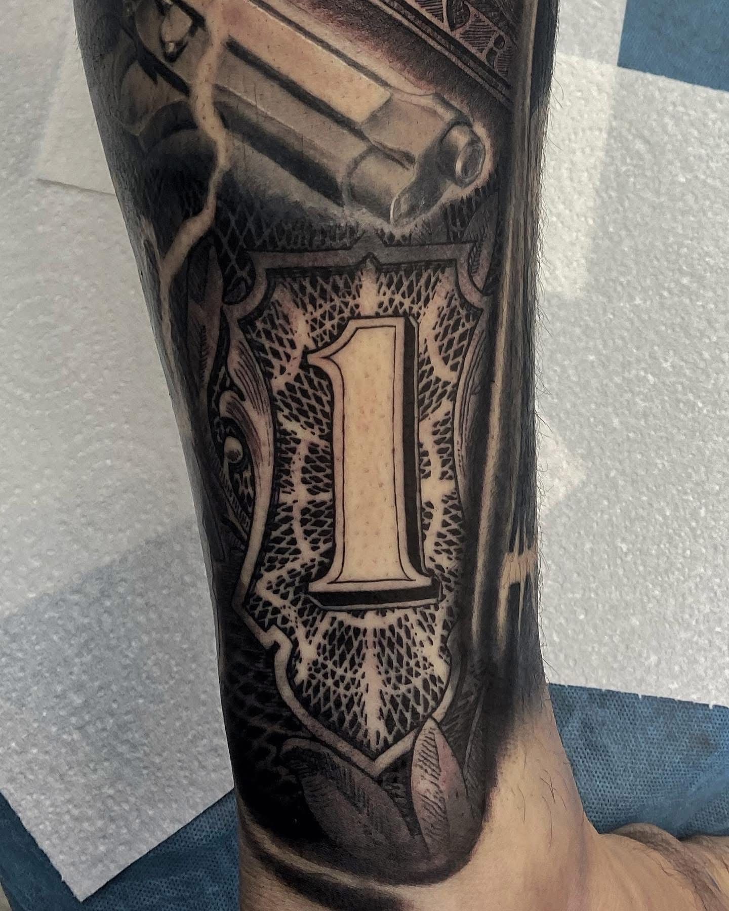 Tattoo on arm, dollar bill design with large 