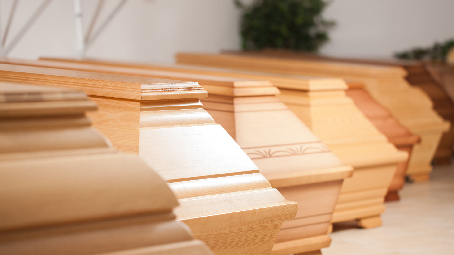 A row of wooden coffins are lined up in a room.