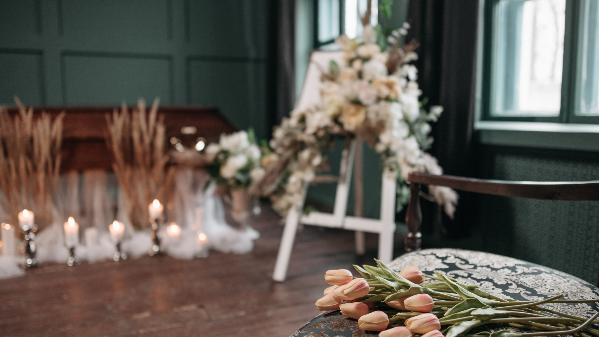 A room decorated with flowers and candles for a funeral.
