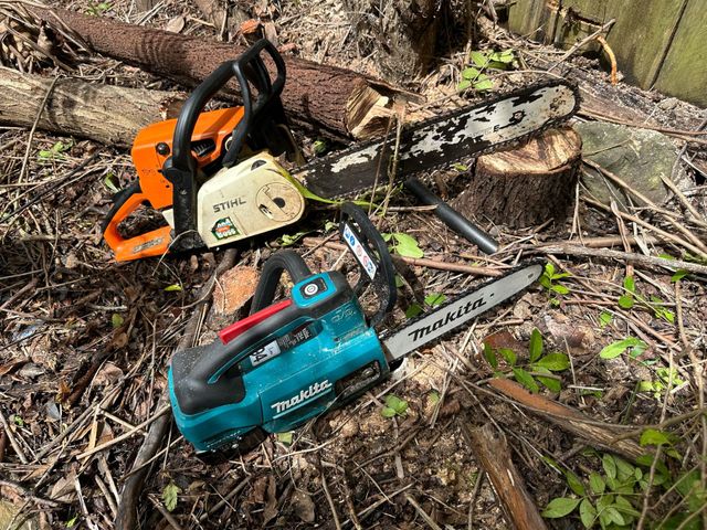 Two chainsaws are sitting on the ground next to a tree stump | MowAbility Garden Services Gold Coast