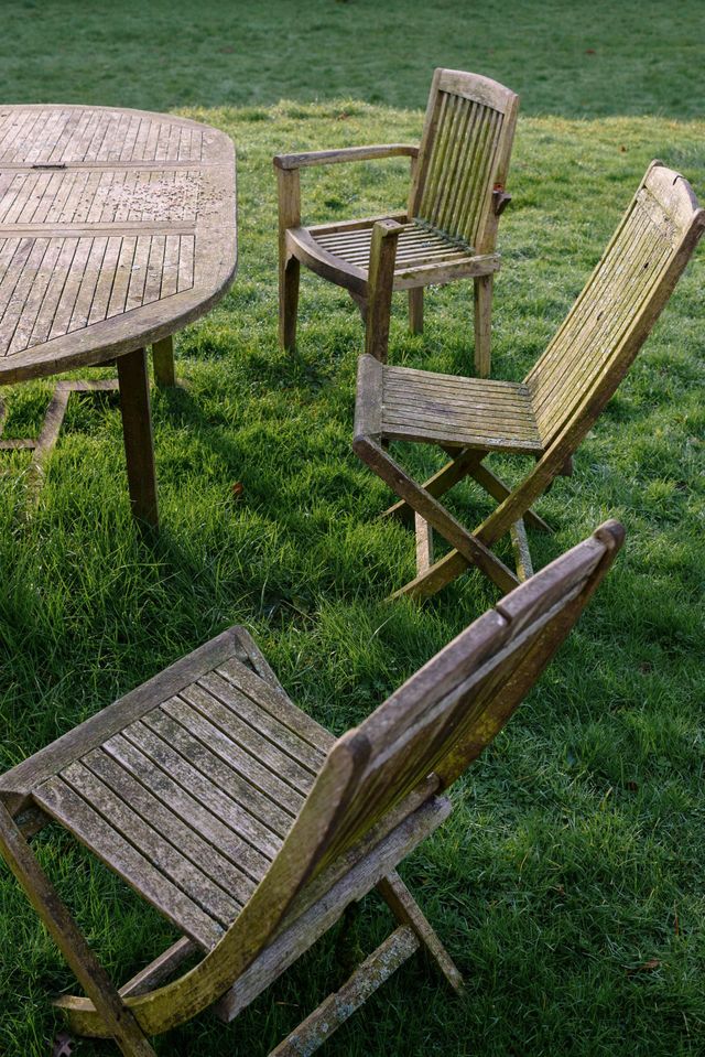 A wooden table and chairs are sitting in the grass | MowAbility Garden Services Gold Coast