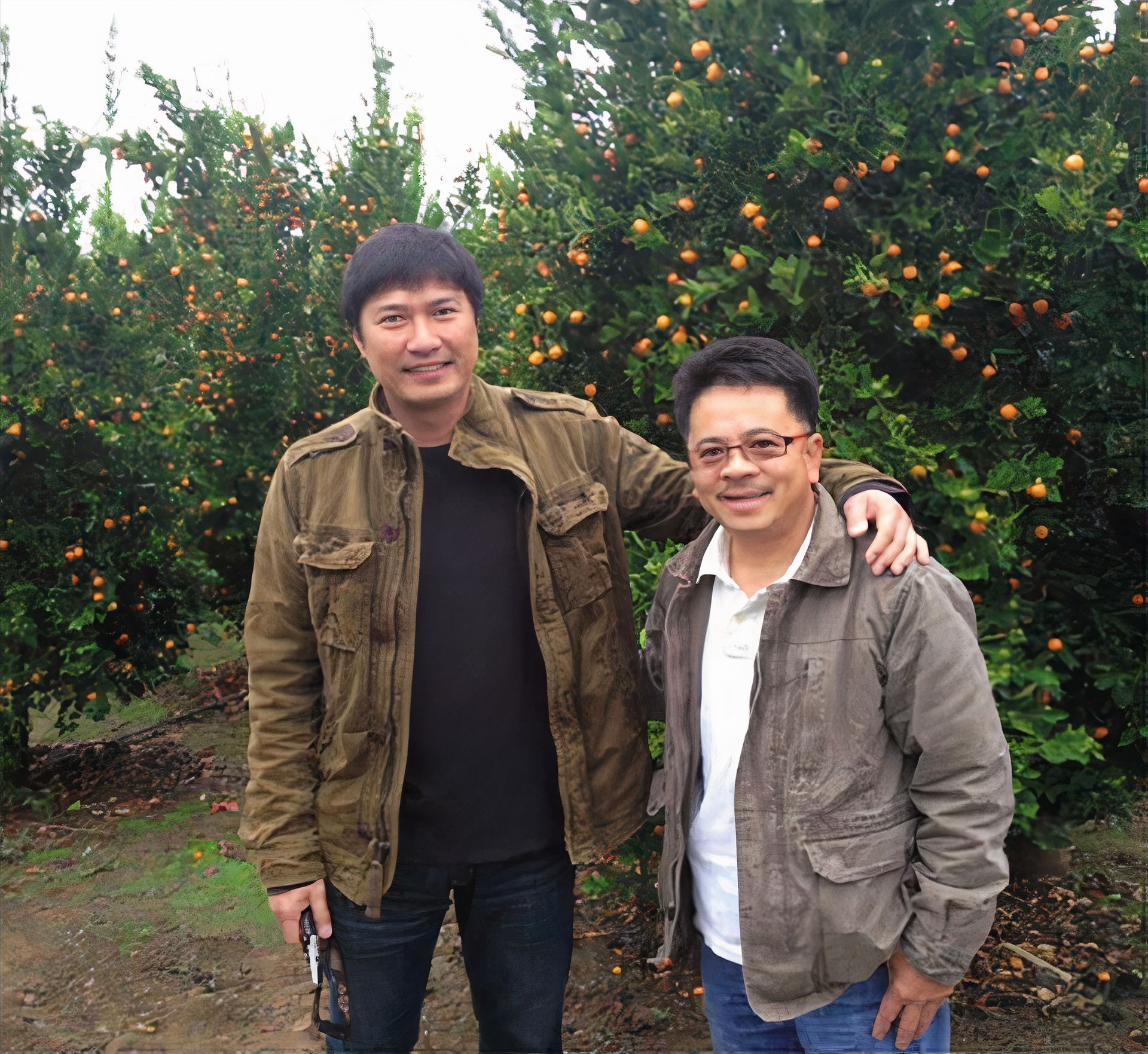 Two Nomsi founders standing in front of a calamansi tree