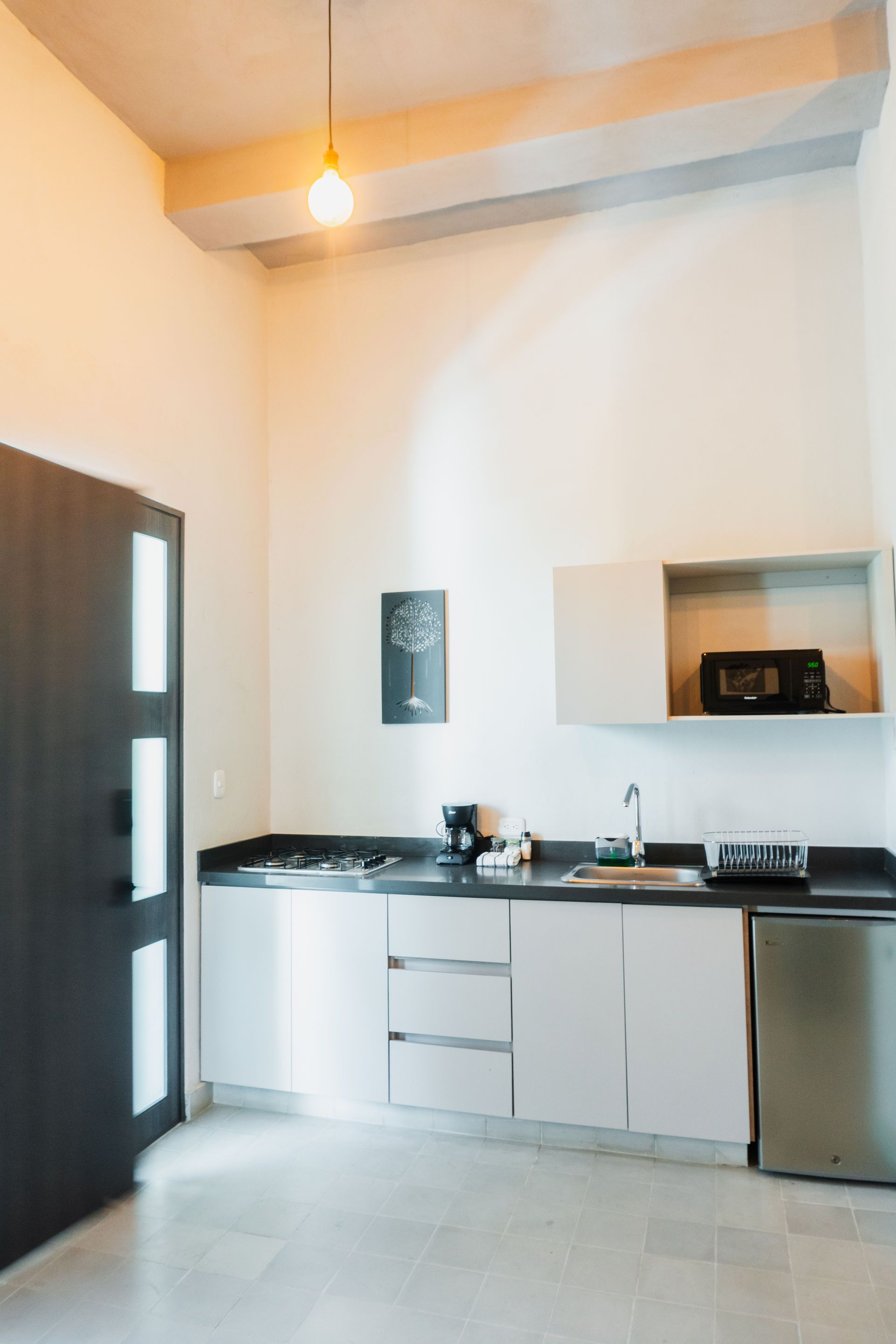 Cocina moderna con gabinetes blancos, electrodomésticos de acero inoxidable y encimeras oscuras.