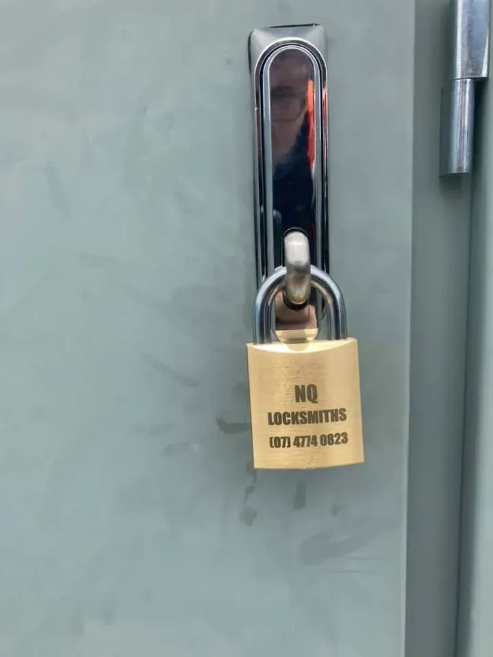 A Gold Padlock on A Gray Metal Door — Nq Locksmiths In Kirwan, QLD