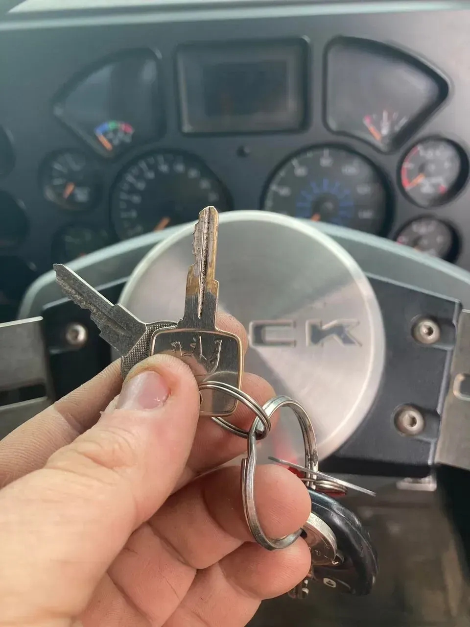 Man Holding a Key by The Steering Wheel — Nq Locksmiths In Kirwan, QLD