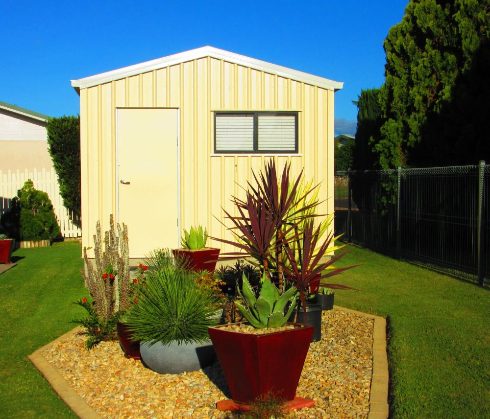 A Black Garage With a Dog Standing in Front of It — Mareeba Sheds & Gas In Mareeba, QLD