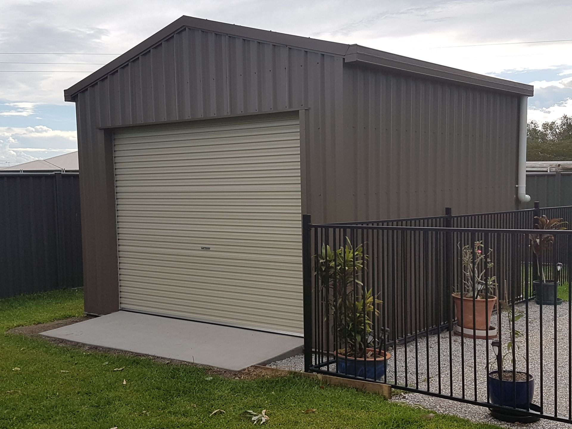 A House With a Garage Door and a Gutter on the Side of It — Mareeba Sheds & Gas In Cairns, QLD