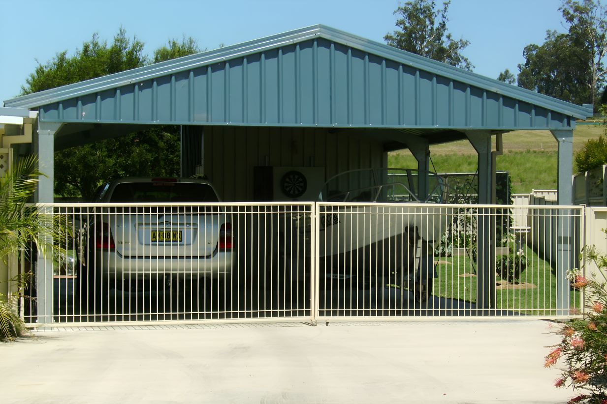 A Car is Parked Under a Carport With a Fence Around It — Mareeba Sheds & Gas In Tablelands, QLD