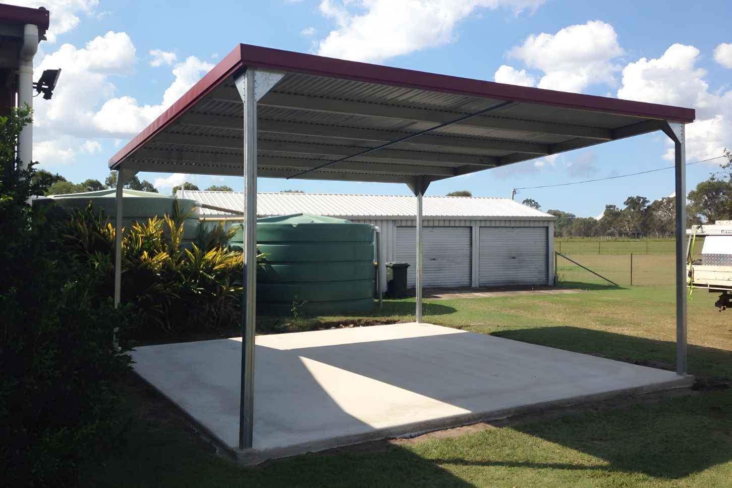 A Carport With a Red Roof and a Concrete Floor — Mareeba Sheds & Gas In Mareeba, QLD