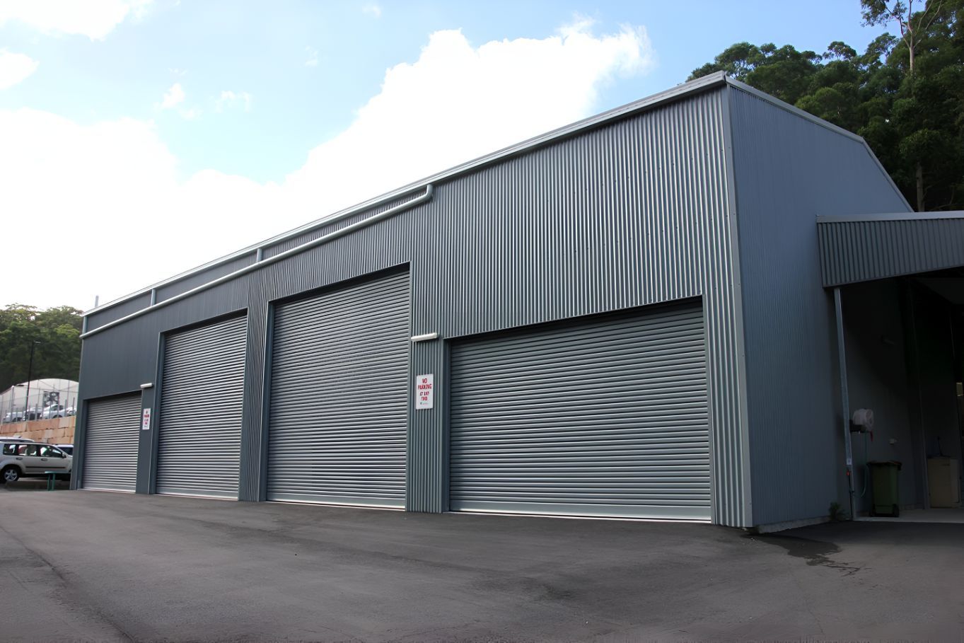 A Building With a Lot of Garage Doors and a Sign That Says No Parking — Mareeba Sheds & Gas In Tablelands, QLD