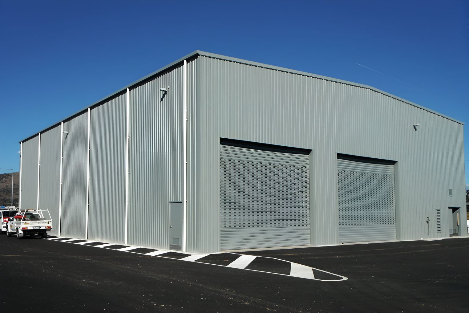 A Large Building With a Lot of Doors and a Truck Parked in Front of It — Mareeba Sheds & Gas In Port Douglas, QLD