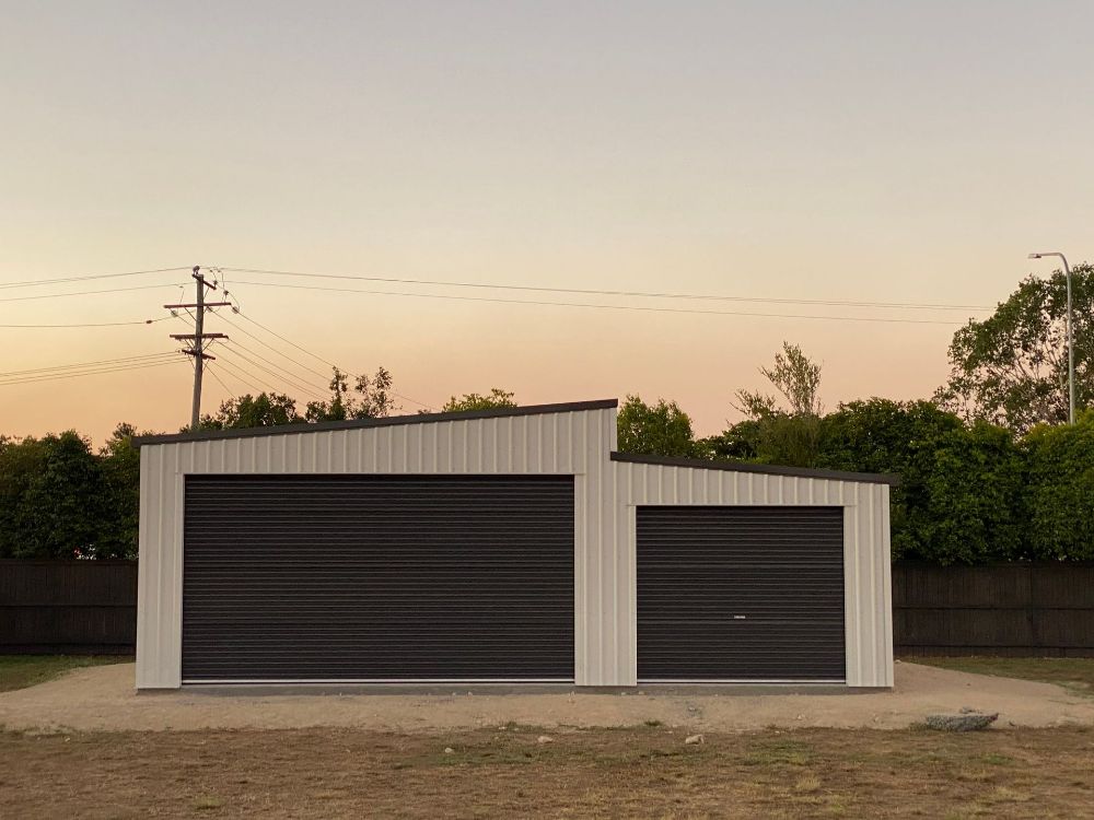 A Blue Truck is Parked in a Garage Next to a House — Mareeba Sheds & Gas In Mareeba, QLD