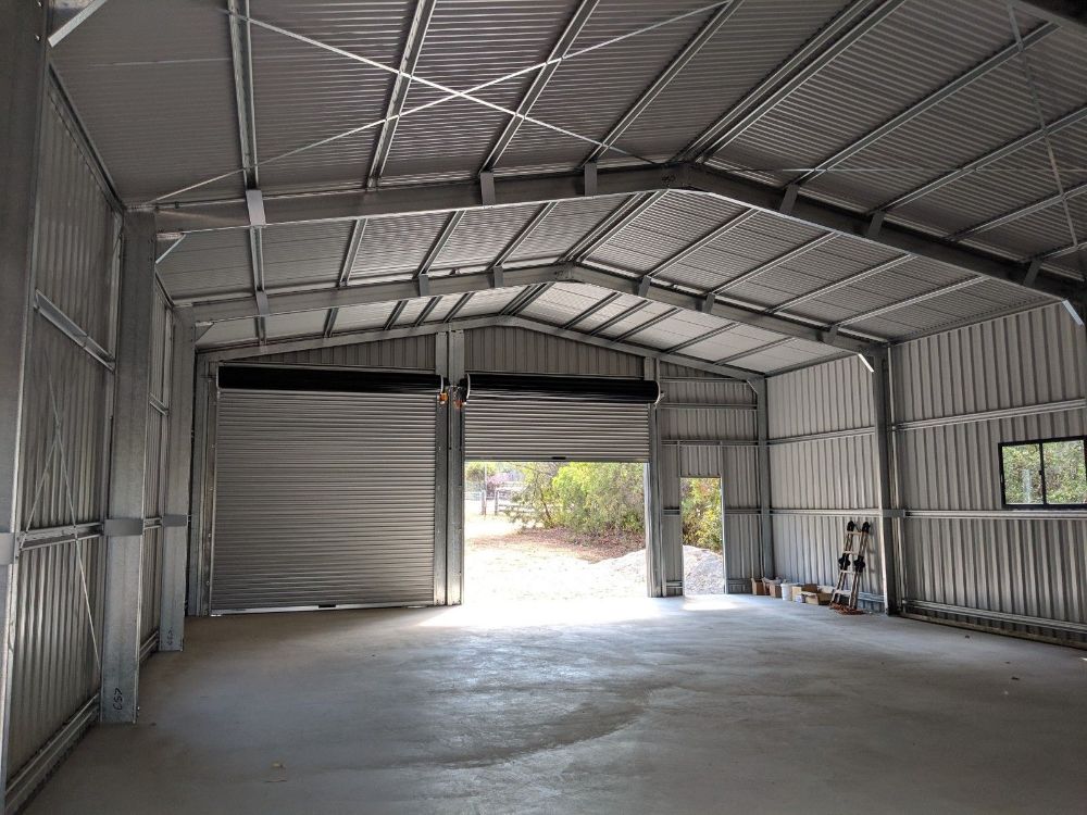 A White Van is Parked in Front of a Large Building in a Parking Lot — Mareeba Sheds & Gas In Mareeba, QLD