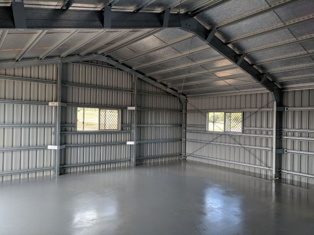 A Large Warehouse With Cars Parked Inside of It — Mareeba Sheds & Gas In Mareeba, QLD