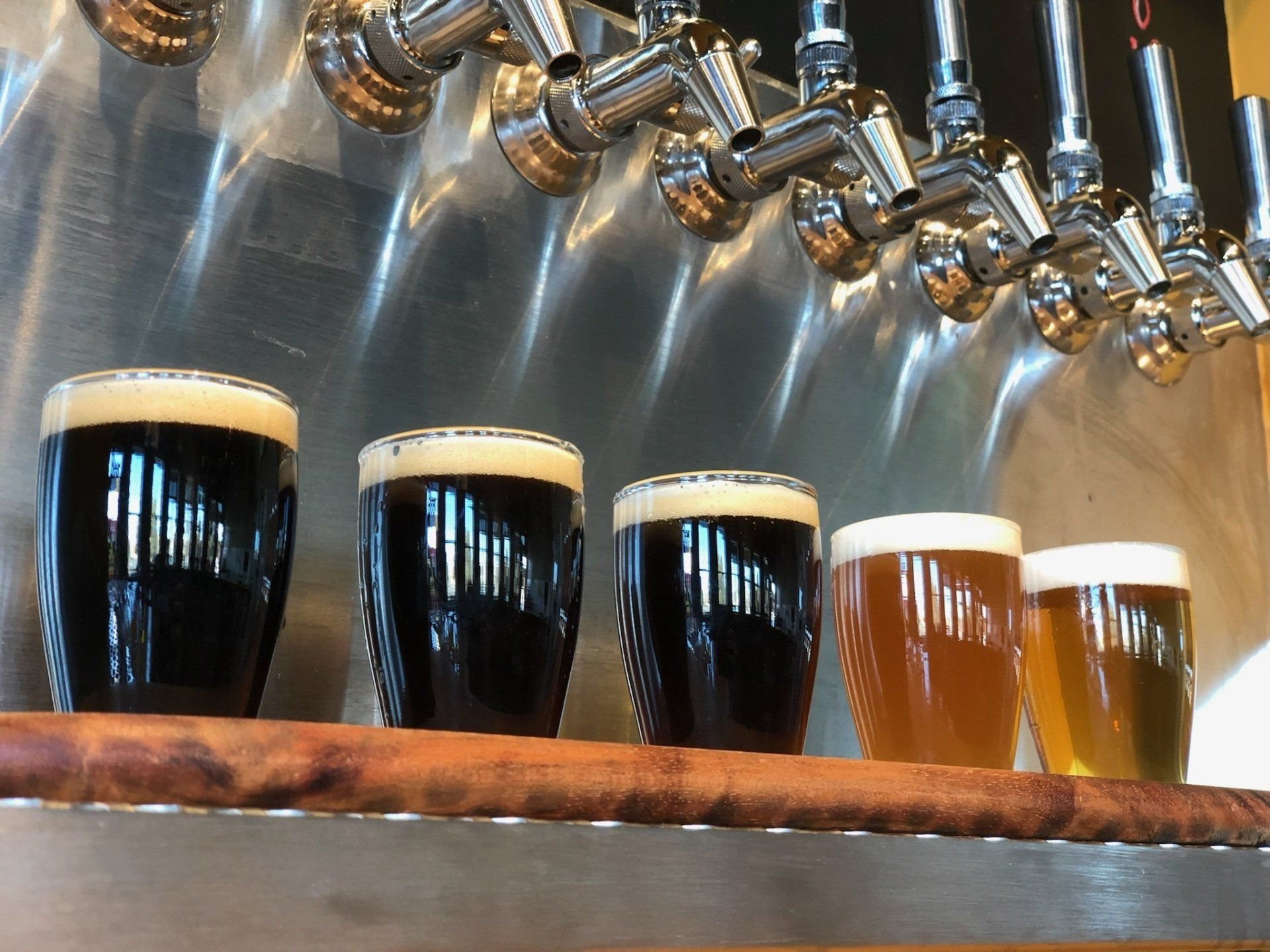 A row of beer glasses filled with different types of beer