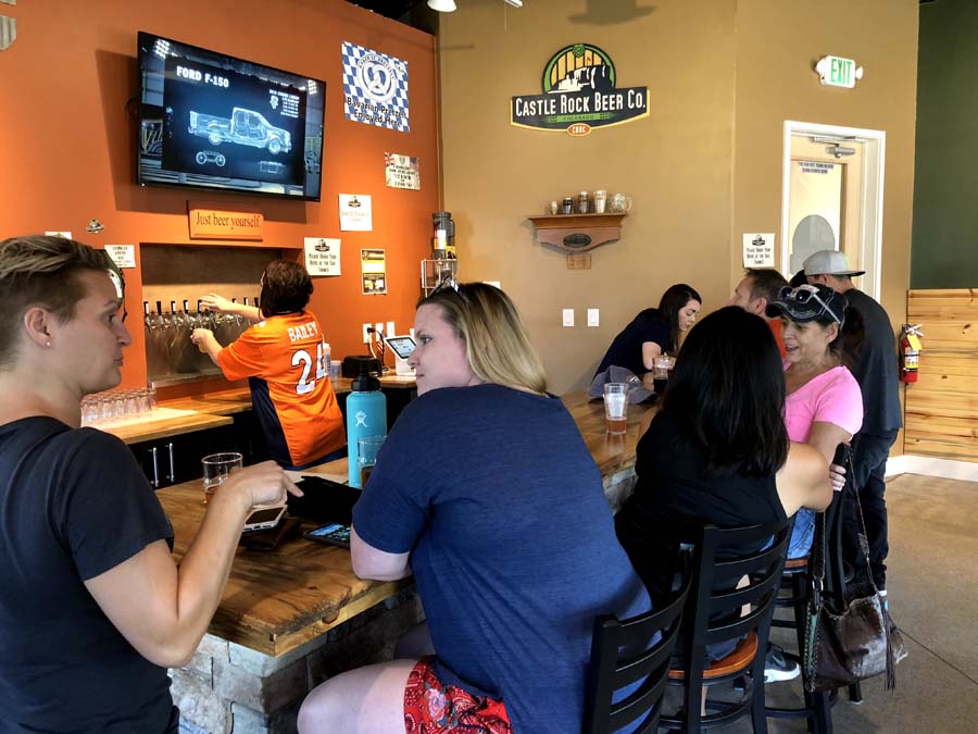 A group of people are sitting at a bar in a restaurant.